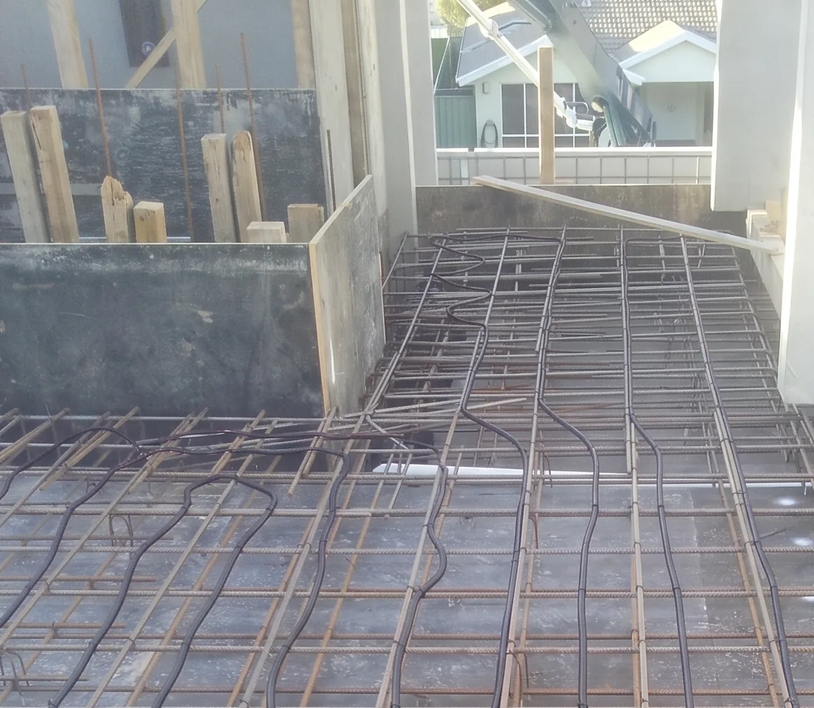 Cable fixed to the reinforcing mesh of a new extension slab, with the formwork still in place.