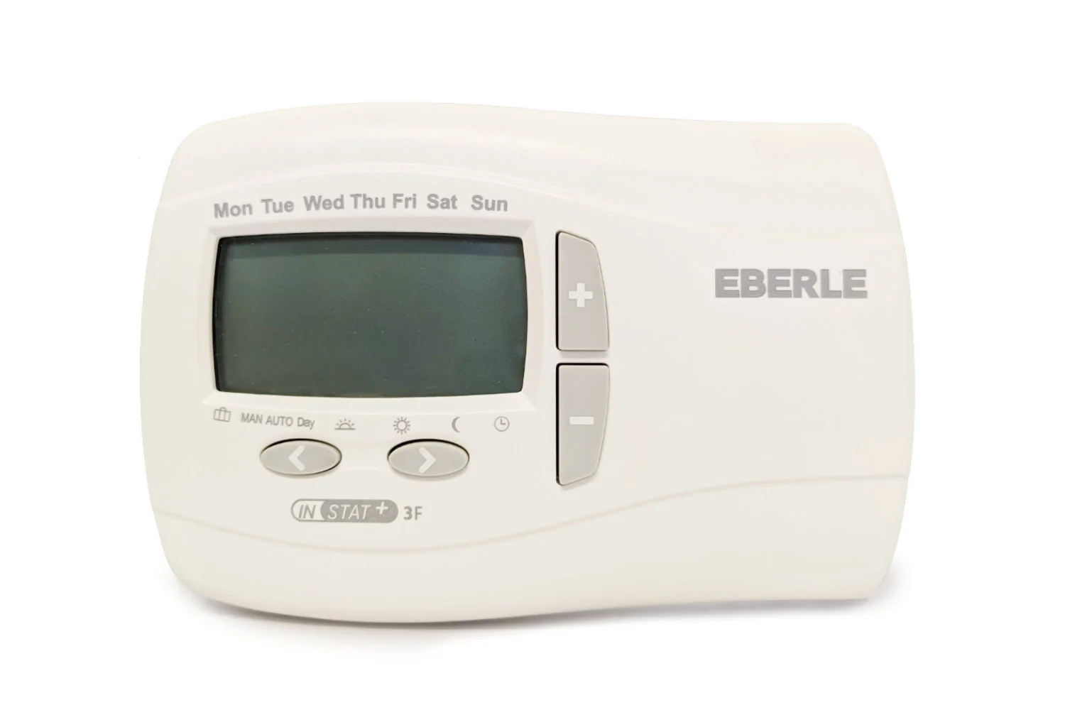 Rectangular cream wall unit with "EBERLE" on the right, a large blank LCD, the days "Mon Tue Wed Thu Fri Sat Sun" printed above it, mode symbols reading "MAN AUTO Day" with sun, moon and clock icons, left and right arrow buttons and plus and minus buttons, marked "INSTAT + 3F" at the bottom.